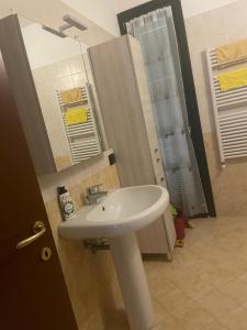 een badkamer met een witte wastafel en een spiegel bij Ami Affittacamere 3 in Castel San Giovanni