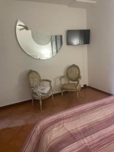 een kamer met 2 stoelen en een spiegel bij Ami Affittacamere 3 in Castel San Giovanni