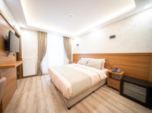 a hotel room with a bed and a flat screen tv at Zirvesta Otel in Istanbul +19 photos