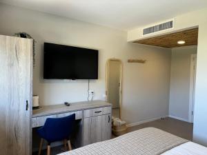 a room with a bed and a tv on the wall at מלון המושבה כפר תבור in Kefar Tavor