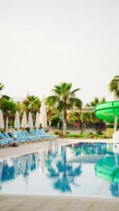 una piscina en un resort con sillas y un tobogán de agua en Rizom Beach Hotel Kumluca, en Kumluca 92 fotos más