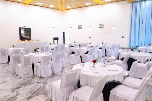 a room full of tables and chairs with white linens at Foxoso Misty Oaks - Hotel & Resort in Bhowāli +48 photos