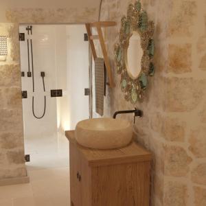 een badkamer met een wastafel en een spiegel bij Borgo Pascarosa in Ostuni +21 foto's