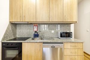 a kitchen with a sink and a microwave at Two 2 Two Urban Stay in Vila Real