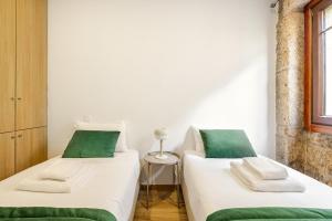 two beds in a room with green and white at Two 2 Two Urban Stay in Vila Real