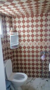 ein Badezimmer mit Toilette und gefliester Wand in der Unterkunft casa carmen medina asilah  + 3 Fotos