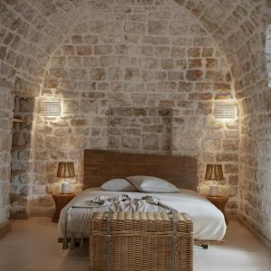 een slaapkamer met een bed in een stenen muur bij Borgo Pascarosa in Ostuni