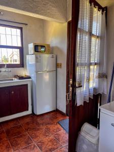 a kitchen with a white refrigerator and a sink at Country del Sol Complejo Turistico in La Paloma
