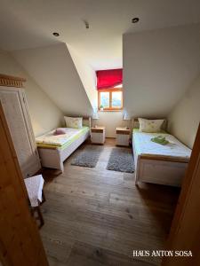 een zolderkamer met twee bedden en een raam bij Ferienhaus Anton in Eibenstock