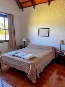 a bedroom with a bed with two lamps and a window at Country del Sol Complejo Turistico in La Paloma