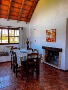 a dining room with a table and a fireplace at Country del Sol Complejo Turistico in La Paloma