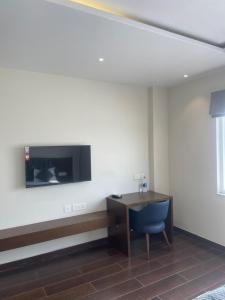 Una habitación con un escritorio y un televisor en la pared. en TIRUPATI WHITE - Hotel & Restaurant, en Kekri