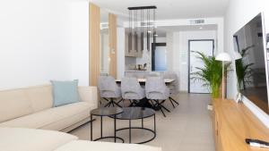 a living room with a couch and a table and chairs at SUNSET SAILORS lovely apartment in Benidorm