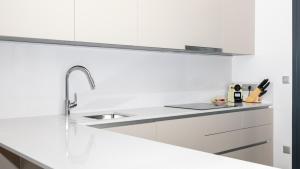 a white kitchen with a sink and white cabinets at SUNSET SAILORS lovely apartment in Benidorm