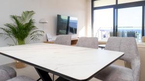 a meeting room with a white table and chairs at SUNSET SAILORS lovely apartment in Benidorm +35 photos