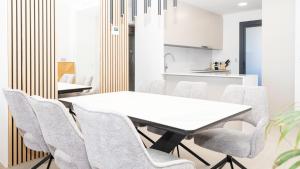 a dining room with a white table and chairs at SUNSET SAILORS lovely apartment in Benidorm