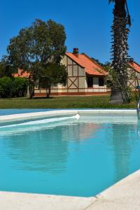 a large swimming pool with a house in the background at Country del Sol Complejo Turistico in La Paloma