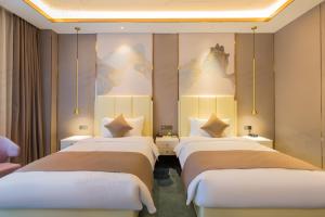 Una habitación con tres camas y un cuadro en la pared. en Beijing Tiananmen Wangfujing Meilun Hotel, en Beijing