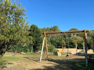 a playground with two swings and a swing at Blu Marlin Apartment in Santa Maria Coghinas