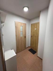 een hal met twee houten deuren en een tegelvloer bij Apartament pod wieżą in Głogów