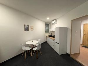een keuken met een tafel, stoelen en een koelkast bij Apartament pod wieżą in Głogów