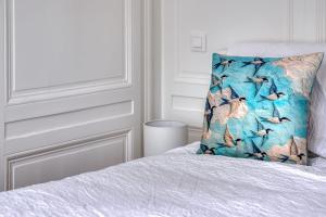 ein Schlafzimmer mit einem Bett mit einem Vogelkissen darauf in der Unterkunft Blue Bird charmant studio avec place de parking ! in Rouen