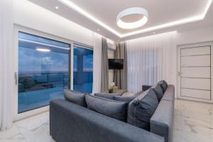 un soggiorno con un divano e una grande finestra di Villa Orizzonte- First Floor Apartment a Città di Zante