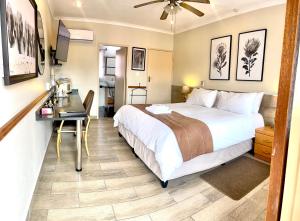 Una habitación de hotel con una cama, un escritorio y una mesa. en Clubview Guest House, en Centurion