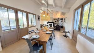 a dining room with a long wooden table and chairs at Charmante maison à deux pas de la plage in Les Portes +6 photos