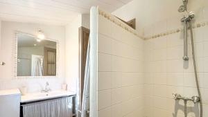a white bathroom with a shower and a sink at Charmante maison à deux pas de la plage in Les Portes