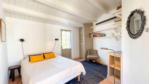 a bedroom with a bed with yellow pillows on it at Charmante maison à deux pas de la plage in Les Portes