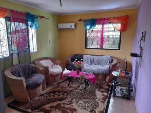 un soggiorno con sedie in vimini e un tavolo di La casa a Kribi