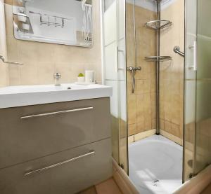 a bathroom with a shower and a sink and a glass shower door at Appartement confortable avec parking et terrasse in Leucate-Plage +21 photos