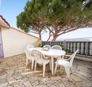 a white table and chairs on a patio at Appartement confortable avec parking et terrasse in Leucate-Plage