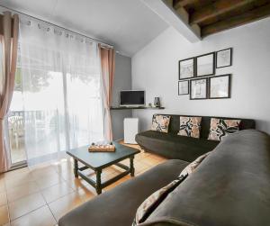 a living room with a couch and a table at Appartement confortable avec parking et terrasse in Leucate-Plage