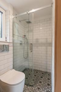 Un baño con inodoro y ducha de cristal. en Tiny Vacation, en Písek 58 fotos más