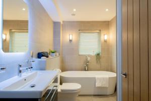 a bathroom with a tub and a toilet and a sink at Landal Hexham Lodges in Slaley +18 photos