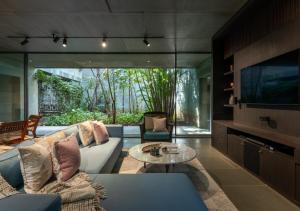 a living room with a couch and a tv at LohonoStays Villa Gomti in Lonavala