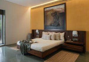a bedroom with a large bed and a painting on the wall at LohonoStays Villa Gomti in Lonavala +43 photos
