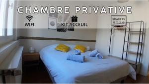 安纳马斯Coliving moderne à Annemasse的一张白色的床,上面有蓝色枕头