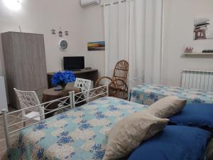a bedroom with two beds and a desk with a computer at Alba Ionica Taranto in Taranto