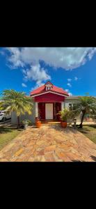 圣弗朗索瓦Villa malaurelia的一座红色屋顶的房子和两棵棕榈树