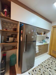 a kitchen with a stainless steel refrigerator and shelves at Estúdio dos sonhos in Rio de Janeiro +3 photos
