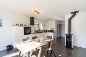 eine Küche und ein Esszimmer mit einem Holztisch und Stühlen in der Unterkunft Ty Menez - Maison neuve proche commerces et plages in Pordic
