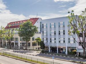 un edificio blanco con techo rojo en una calle en Hotel 81 Kovan, en Singapur