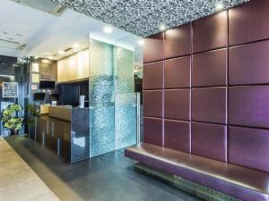 Un vestíbulo con paredes moradas y un banco. en Hotel 81 Kovan, en Singapur