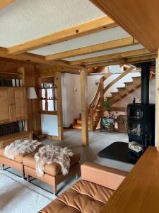 un soggiorno con un divano e una scala di Lakeview Swiss Chalet with Hot Tub near Interlaken a Niederried