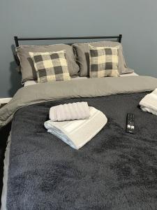 a bed with two towels and pillows on it at Modern Studio Central WV1 Appt 4 in Wolverhampton