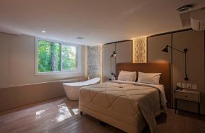 グラマドにあるHarmont Hotelのベッドルーム1室(ベッド1台、バスタブ、窓付)