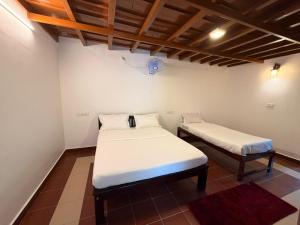 ein Schlafzimmer mit zwei Betten in einem Zimmer in der Unterkunft Wildcrest Homestay in Madikeri